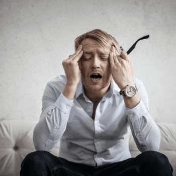 Stressed man holding his head, illustrating how overwhelmed users behave during urgent moments on a website — Imagine Monkey web design Orange County.