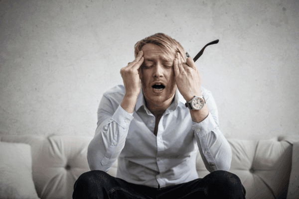 Stressed man holding his head, illustrating how overwhelmed users behave during urgent moments on a website — Imagine Monkey web design Orange County.