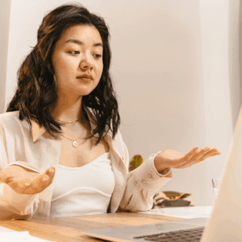 Person looking confused at their laptop, illustrating how website visitors react when pages overexplain and lack clarity.