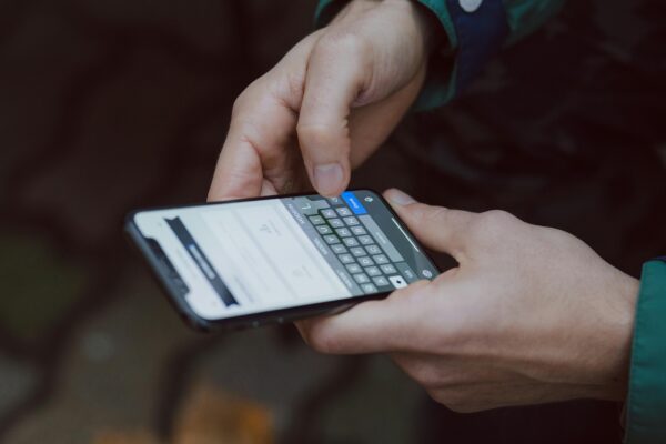 Person typing on a smartphone while navigating a website on mobile, illustrating a mobile menu or navigation issue.